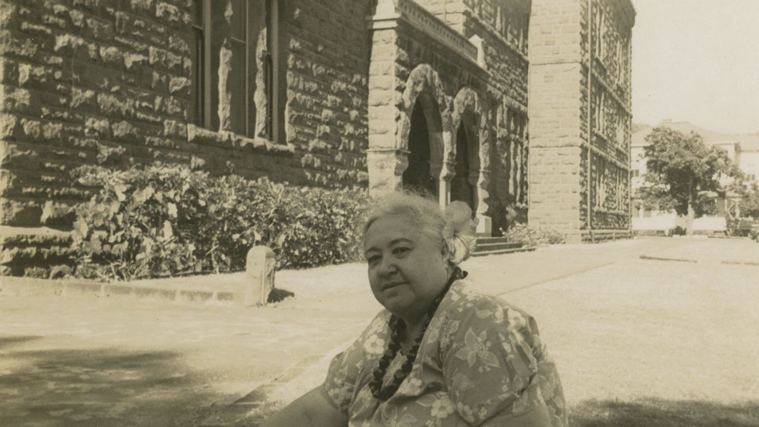 Mary Kawena Pukui sitting outside of Hawaiian Hall. Mrs. Pukui’s prolific legacy of compositions, cultural stories, histories, audio recordings, and ethnographic notes is housed in the Library & Archives. (SP 86426, Bishop Museum Archives)